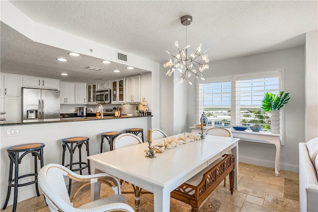 2700 Ocean Dr Unit 405, Vero Beach, FL 32963 - dining space with a textured ceiling, baseboards, visible vents, a notable chandelier, and recessed lighting