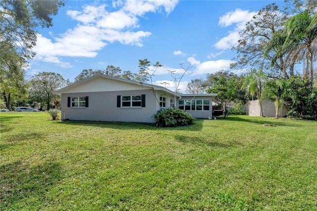 rear view of property featuring a lawn