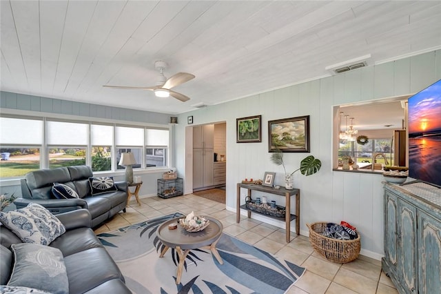 tiled living room with a healthy amount of sunlight, ceiling fan, wooden ceiling, and wood walls