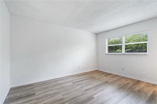 empty room featuring light hardwood / wood-style floors and a textured ceiling