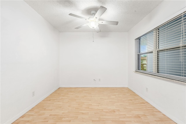 empty room featuring light hardwood / wood-style flooring, a textured ceiling, and ceiling fan