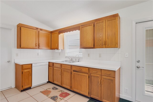 kitchen featuring lofted ceiling, sink, light tile patterned floors, dishwasher, and decorative backsplash