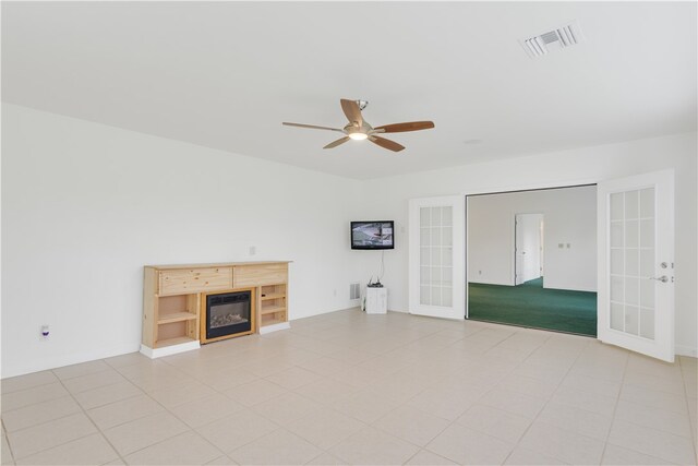 unfurnished living room featuring ceiling fan and french doors