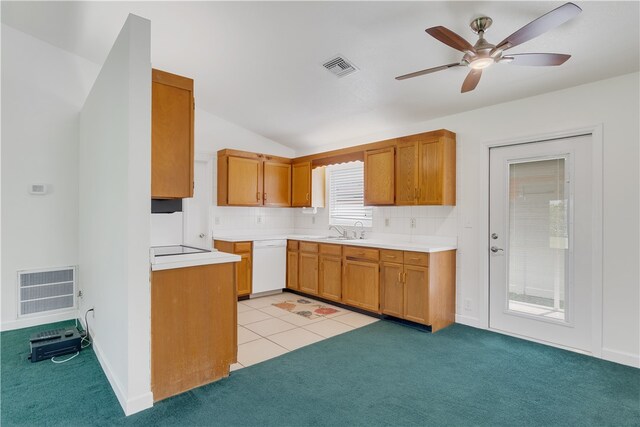 kitchen with light carpet, backsplash, white dishwasher, and vaulted ceiling