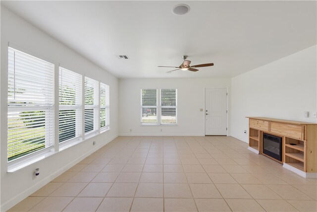 unfurnished living room featuring light tile patterned floors and ceiling fan