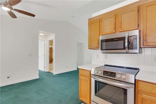 kitchen featuring vaulted ceiling, appliances with stainless steel finishes, backsplash, dark colored carpet, and ceiling fan