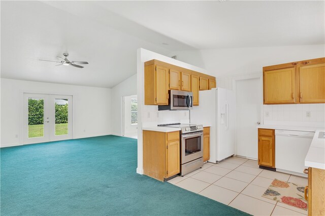 kitchen with vaulted ceiling, appliances with stainless steel finishes, ceiling fan, light carpet, and french doors