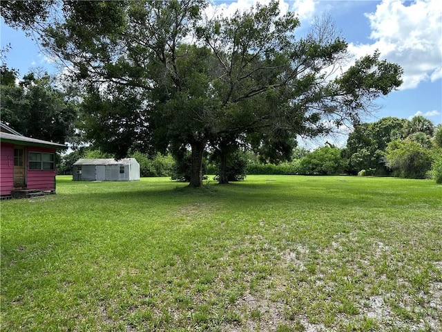 4065 62nd Ct, Vero Beach, FL 32966 - view of grassy yard with an outdoor structure and view of wooded area