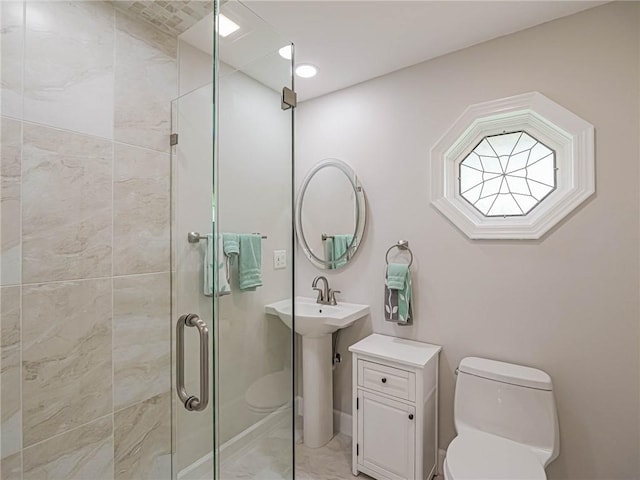 bathroom with a shower with shower door and toilet