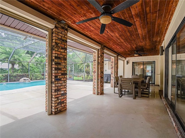 view of patio featuring ceiling fan and glass enclosure