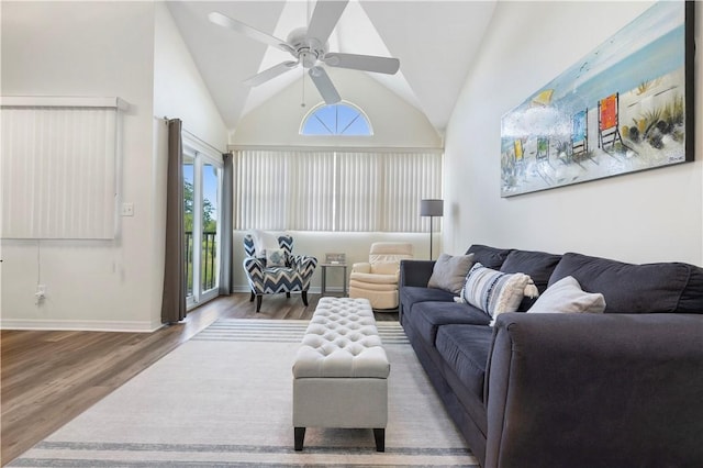 living room with a ceiling fan, wood finished floors, lofted ceiling, and baseboards