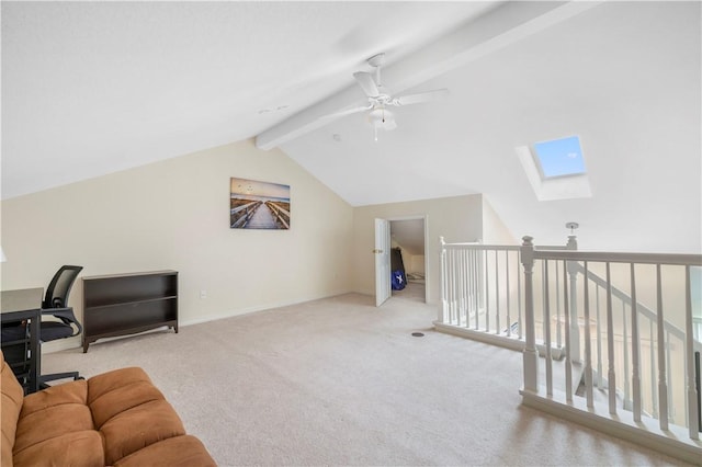 carpeted office space featuring ceiling fan and a skylight