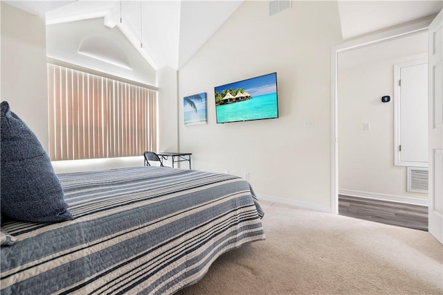 bedroom with lofted ceiling, carpet flooring, attic access, and baseboards