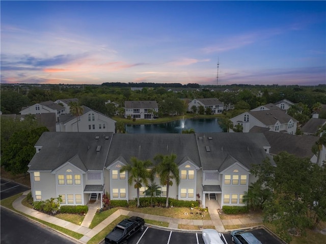 aerial view at dusk of a water view and a residential view