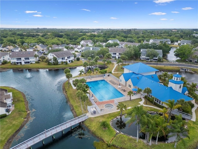 aerial view of residential area with a nearby body of water, a pool, and a notable bridge