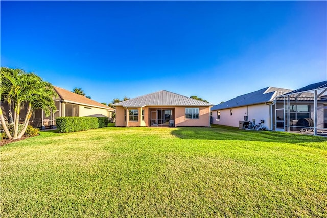 1122 4th Ln SW, Vero Beach, FL 32962 - back of house with a lawn, metal roof, a lanai, and stucco siding
