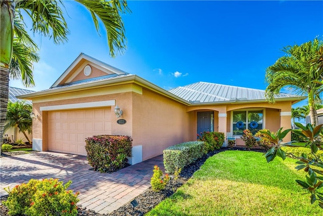 1122 4th Ln SW, Vero Beach, FL 32962 - ranch-style house with stucco siding, an attached garage, a front yard, and decorative driveway