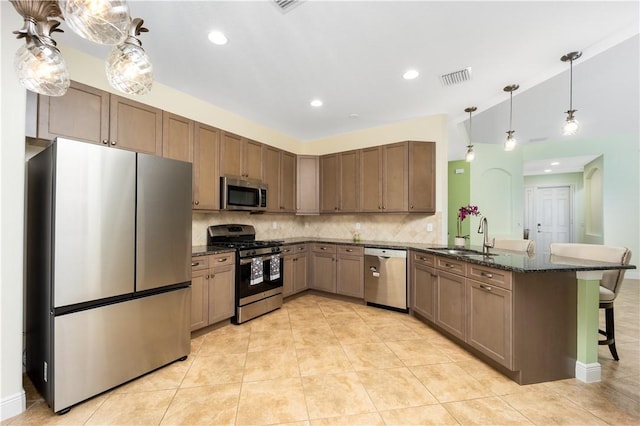 1122 4th Ln SW, Vero Beach, FL 32962 - kitchen featuring appliances with stainless steel finishes, a sink, a peninsula, backsplash, and a breakfast bar