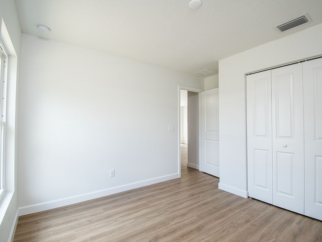 6156 6th Pl, Vero Beach, FL 32968 - unfurnished bedroom with light wood-style floors, a closet, and baseboards