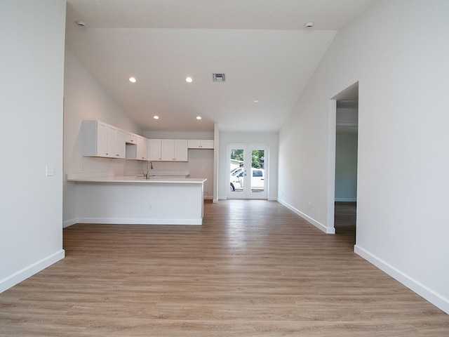 6156 6th Pl, Vero Beach, FL 32968 - unfurnished living room with lofted ceiling, recessed lighting, light wood finished floors, a sink, and baseboards