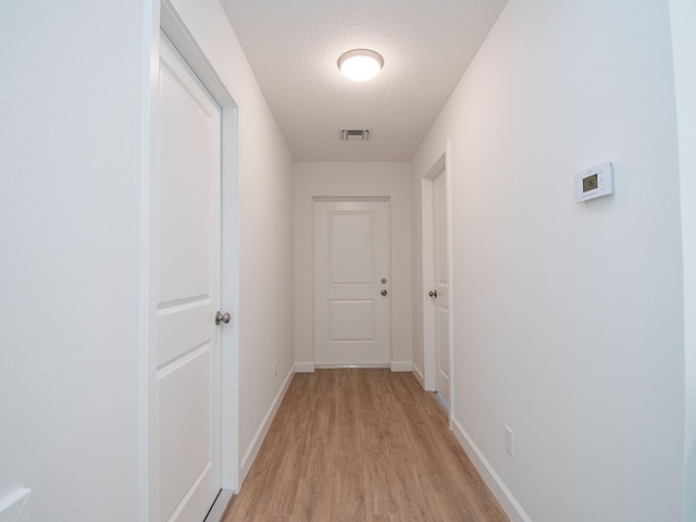 6156 6th Pl, Vero Beach, FL 32968 - corridor featuring light wood-type flooring, a textured ceiling, and baseboards