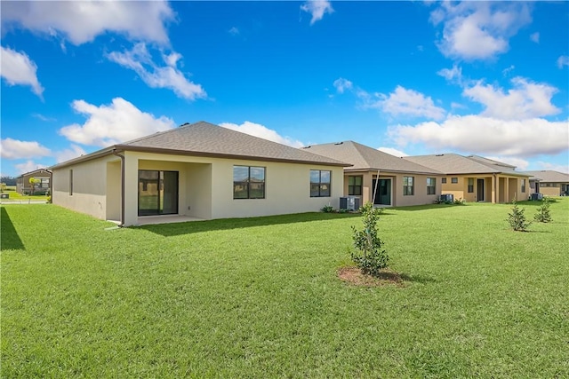 back of property featuring central AC unit and a lawn