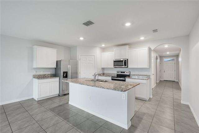 kitchen featuring stainless steel appliances, sink, an island with sink, and white cabinets