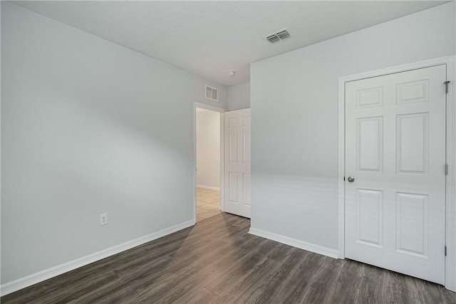 unfurnished bedroom with dark hardwood / wood-style floors