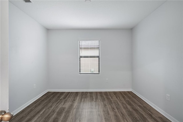 unfurnished room with dark hardwood / wood-style flooring