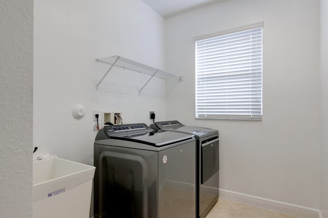 washroom with washer and clothes dryer, light tile patterned floors, and sink