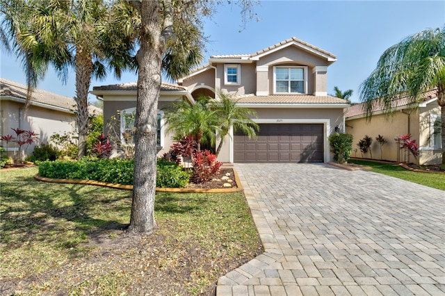 mediterranean / spanish house featuring a front yard and a garage