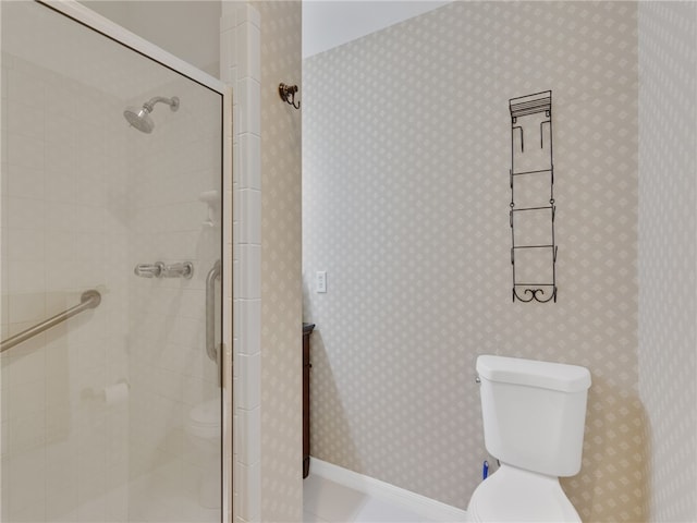 bathroom featuring a shower with door and toilet