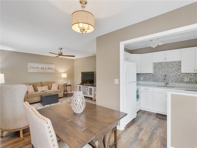 dining room with wood-type flooring, ceiling fan, and sink