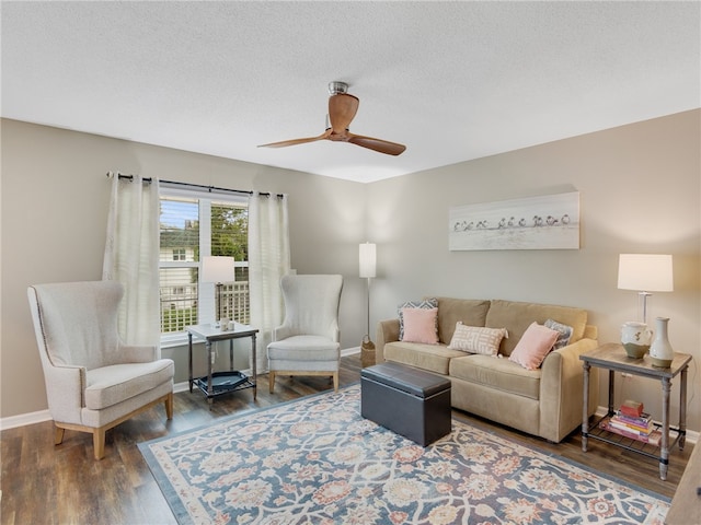 living room with ceiling fan, dark wood-type flooring, and a textured ceiling