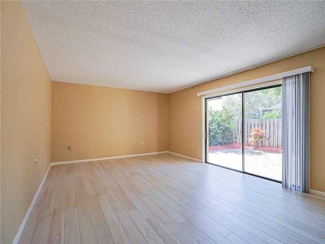 empty room with light hardwood / wood-style floors and a textured ceiling