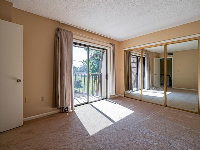 unfurnished room with light colored carpet and a textured ceiling