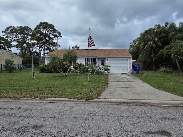 view of front of home featuring a garage, driveway, a front lawn, and fence