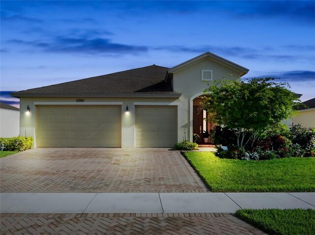 10060 Verona Mnr, Vero Beach, FL 32966 - view of front of house featuring stucco siding, decorative driveway, roof with shingles, and an attached garage