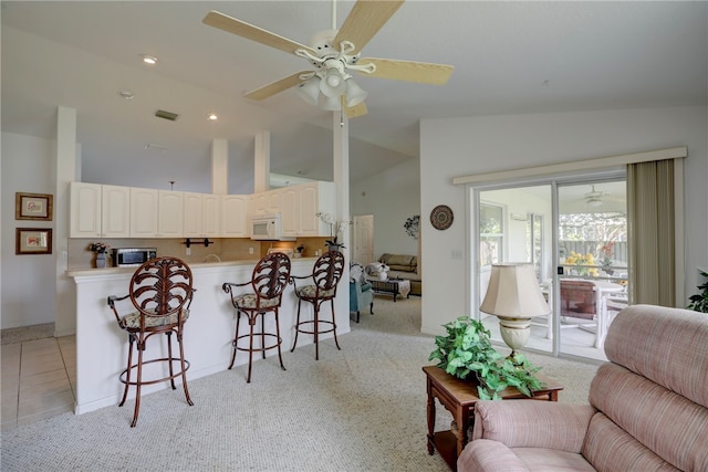 carpeted living room featuring ceiling fan and vaulted ceiling