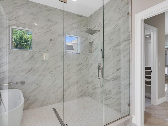 8405 Red Bay Ct Unit 8405, Vero Beach, FL 32963 - bathroom with a marble finish shower, a spacious closet, and a freestanding tub