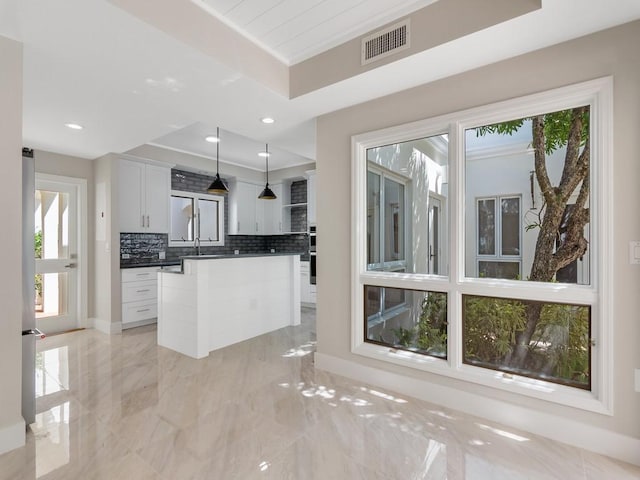 8405 Red Bay Ct Unit 8405, Vero Beach, FL 32963 - kitchen with tasteful backsplash, dark countertops, decorative light fixtures, visible vents, and marble finish floor