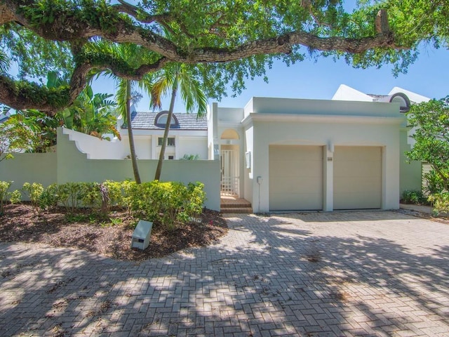 8405 Red Bay Ct Unit 8405, Vero Beach, FL 32963 - view of front of home featuring a garage, a tile roof, fence, stucco siding, and driveway