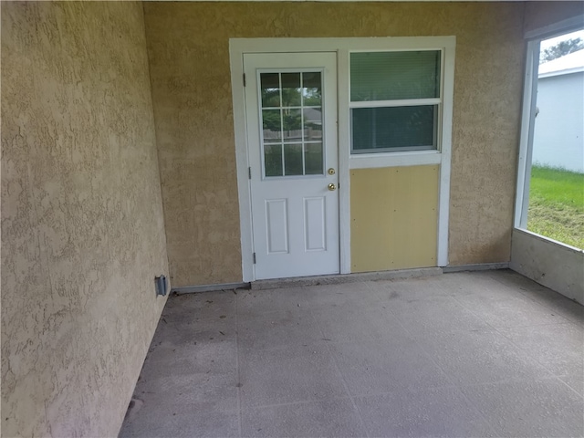 view of exterior entry with a patio