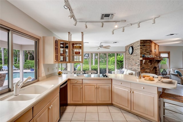 kitchen featuring black appliances, kitchen peninsula, sink, and a healthy amount of sunlight