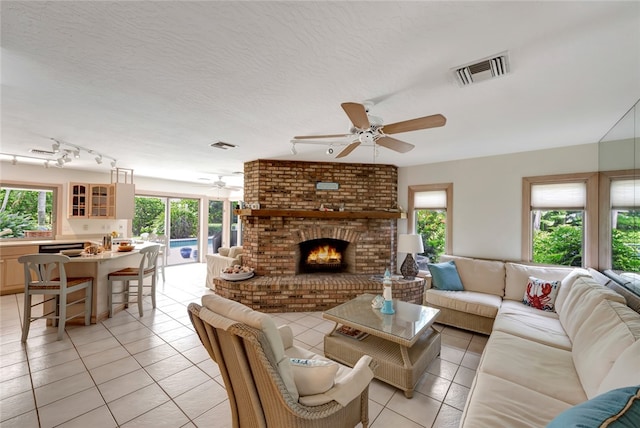 tiled living room featuring a fireplace and a textured ceiling