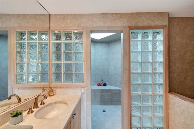 bathroom with vanity, tile walls, and walk in shower