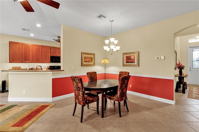 dining space with ceiling fan with notable chandelier, sink, and light tile patterned floors