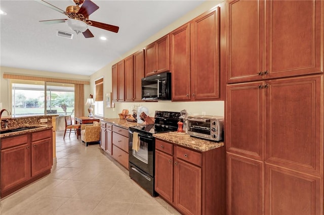 kitchen featuring sink, light tile patterned floors, ceiling fan, black appliances, and light stone countertops