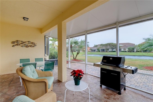 sunroom / solarium featuring a water view