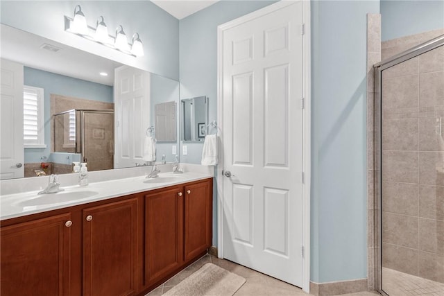 bathroom featuring tile patterned floors, a shower with shower door, and vanity